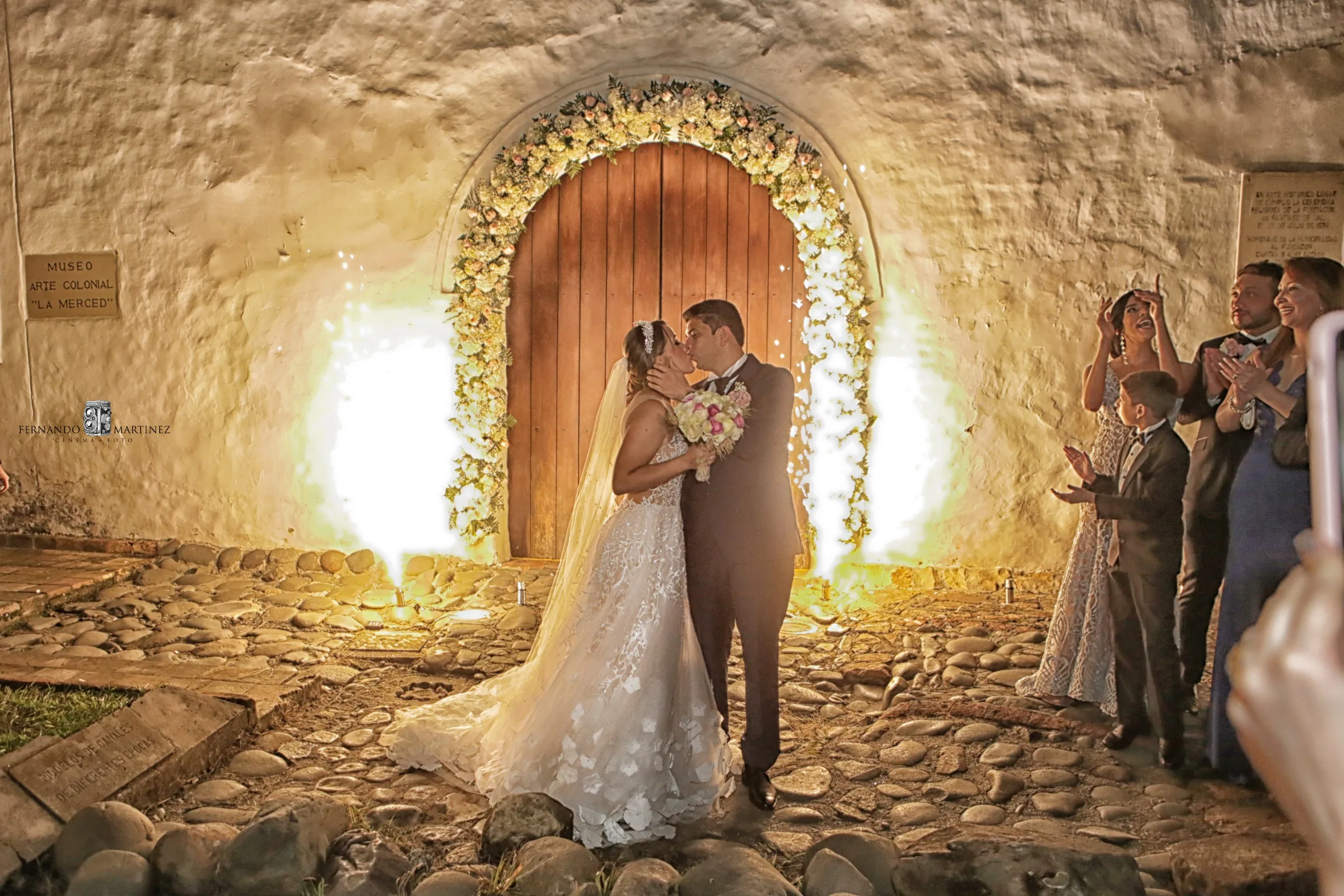 Beso de novios bajo arco colonial